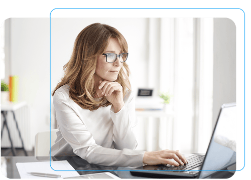 Woman paying bills from her home office desk with a laptop 