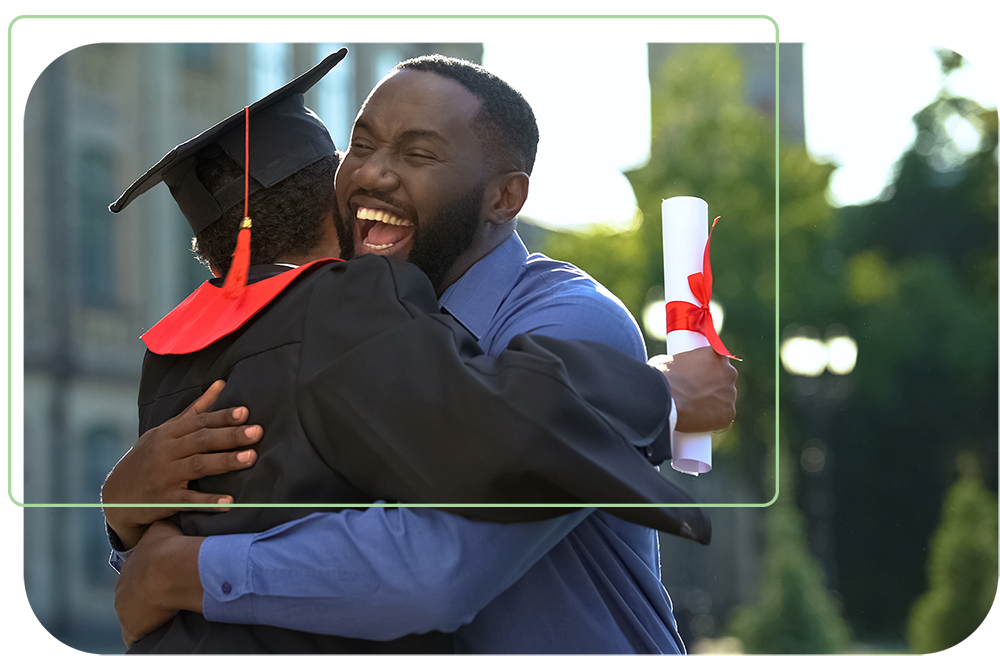 Proud father hugging his child as they graduate college with a diploma in hand