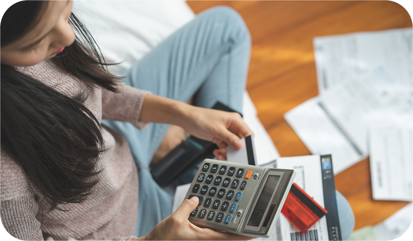woman with calculator looking at her credit score as she applies for a home equity loan