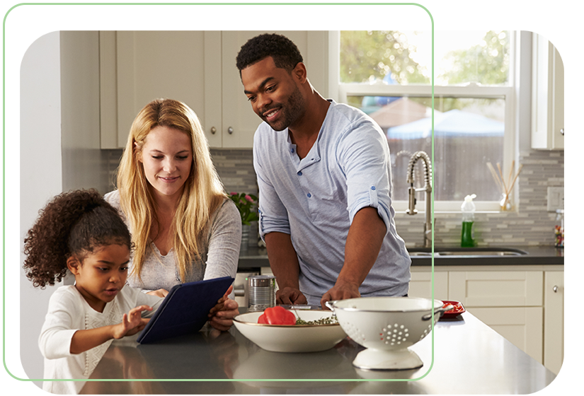 happy family together in renovated kitchen island with little girl on a tablet
