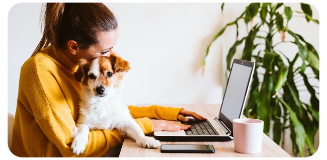 woman applying for a home equity loan on her laptop while snuggling a puppy