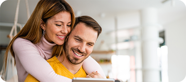 couple watching interest rates drop on their tablet